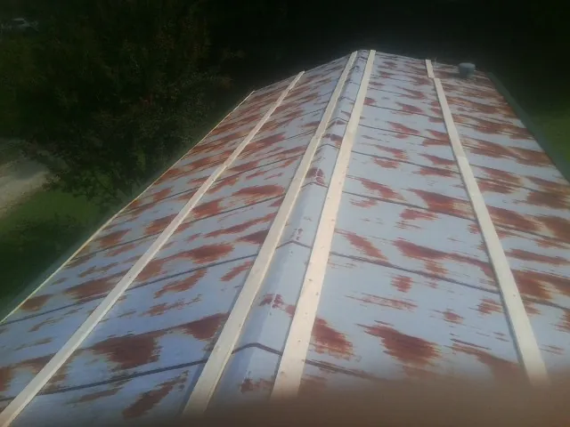 Rusted metal roof panels with new wood purlins before replacement — Storm Damage Roof Repair in Montezuma by Roofing Brothers