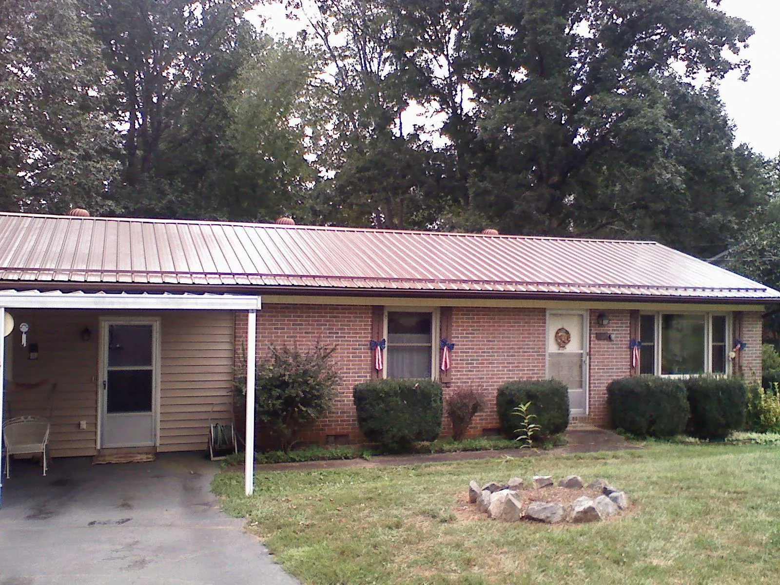 Bronze metal roof and carport on a brick ranch home — Roof Repair work by our crew in Montezuma